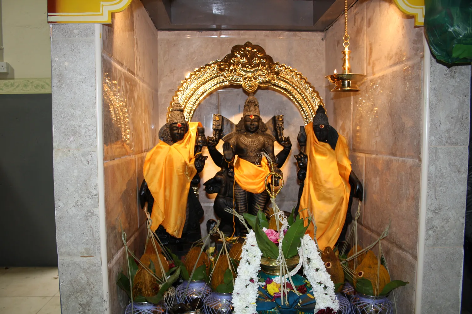 Three deities dressed together in saffron.