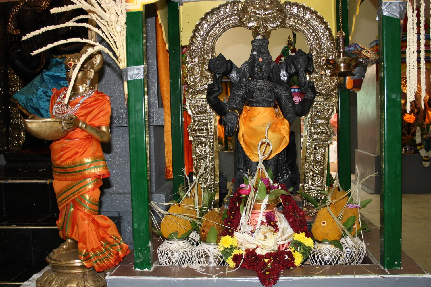 A shrine dressed for the consecration, pots and garlands at its base.